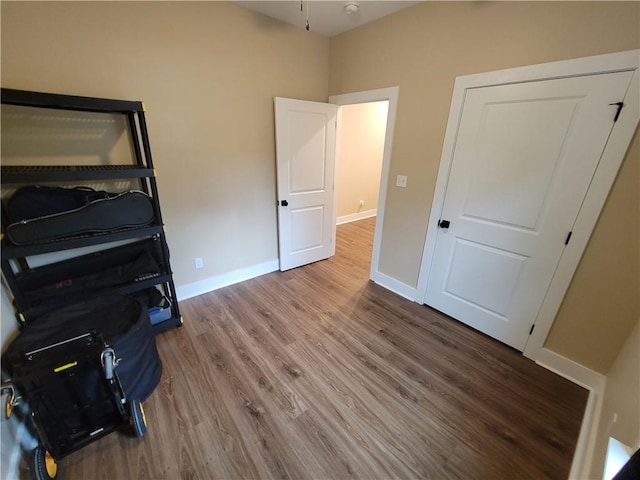 bedroom with baseboards and wood finished floors