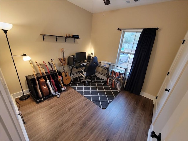 office space featuring a ceiling fan, visible vents, wood finished floors, and baseboards