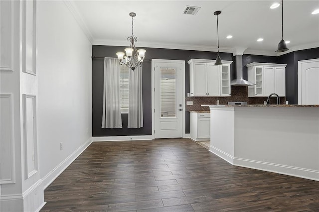 kitchen featuring tasteful backsplash, visible vents, dark wood finished floors, wall chimney exhaust hood, and a sink