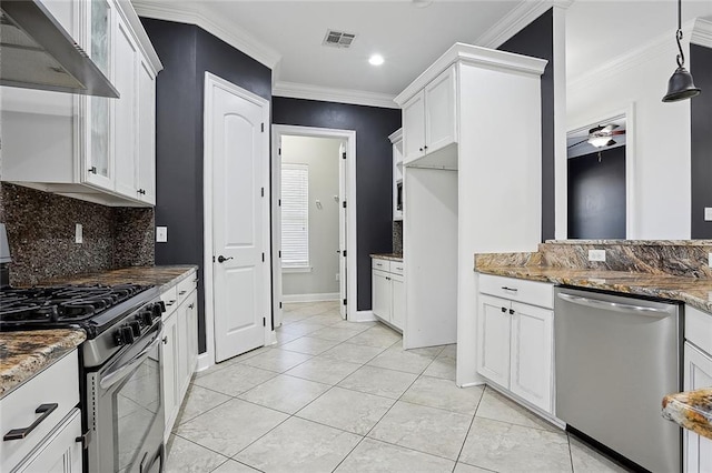 kitchen with dark stone countertops, visible vents, ornamental molding, stainless steel appliances, and wall chimney range hood