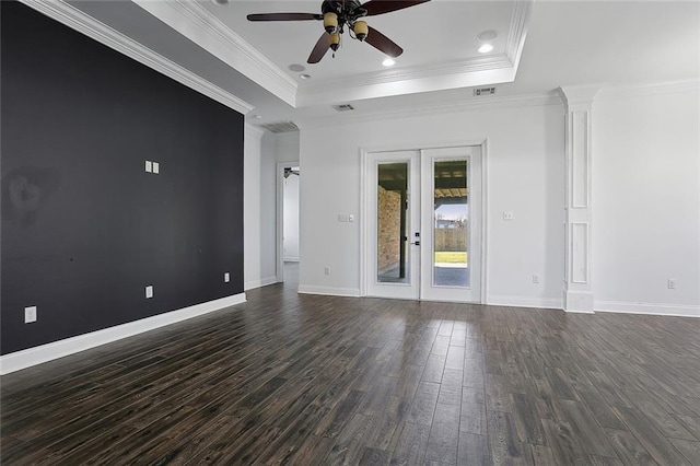 unfurnished room with a raised ceiling, dark wood-style floors, a ceiling fan, and baseboards