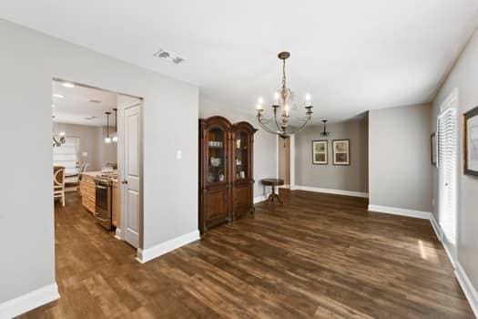 1913 Satsuma St, Metairie, LA 70001 - dining room with a chandelier, dark wood-style flooring, and baseboards