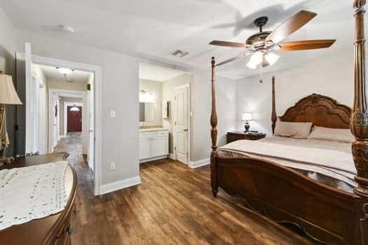 1913 Satsuma St, Metairie, LA 70001 - bedroom featuring dark wood-style floors, baseboards, ensuite bath, and a ceiling fan