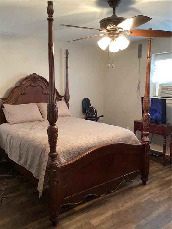 bedroom featuring cooling unit, wood finished floors, and a ceiling fan