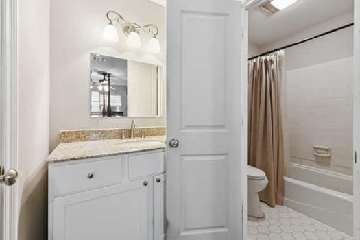 1913 Satsuma St, Metairie, LA 70001 - bathroom with toilet, vanity, tile patterned floors, and shower / bath combination with curtain