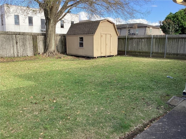 view of yard featuring an outbuilding, a fenced backyard, and a shed