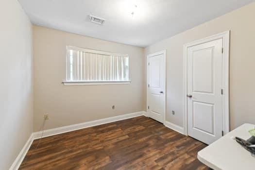 1913 Satsuma St, Metairie, LA 70001 - unfurnished bedroom featuring dark wood finished floors and baseboards