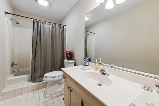 1913 Satsuma St, Metairie, LA 70001 - full bath with toilet, shower / bathtub combination with curtain, vanity, and tile patterned flooring