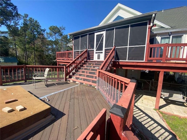 deck featuring stairs and a sunroom