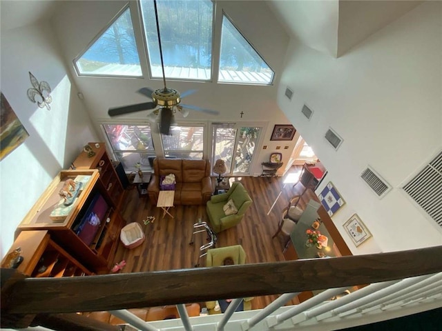 living area featuring plenty of natural light, visible vents, ceiling fan, and wood finished floors