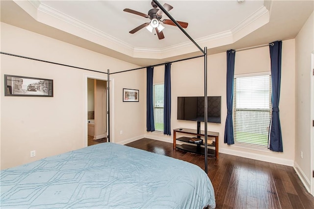 bedroom featuring a tray ceiling, baseboards, hardwood / wood-style floors, and ornamental molding