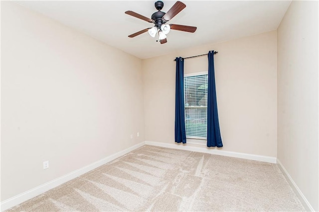 carpeted empty room featuring baseboards and ceiling fan