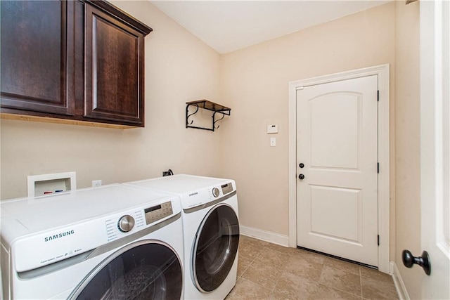 washroom with light tile patterned floors, baseboards, cabinet space, and washing machine and clothes dryer