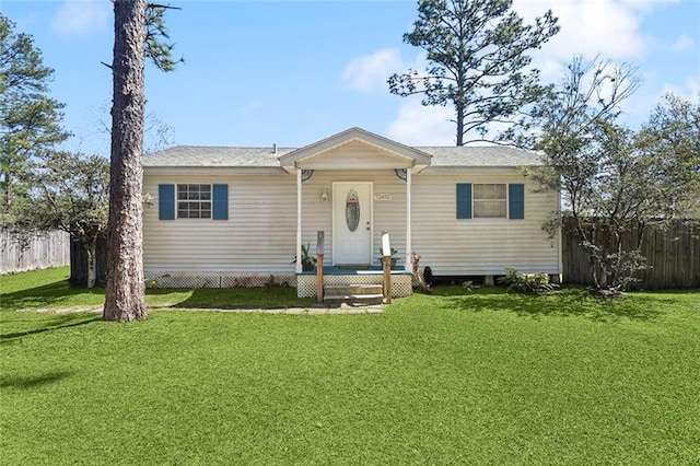 view of front of home featuring a shingled roof, a front yard, and fence