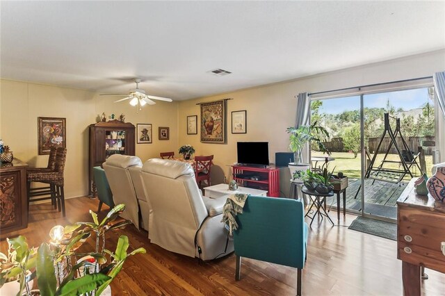 living area featuring visible vents, a ceiling fan, and wood finished floors