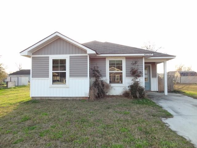 view of front of house featuring an attached carport, a front yard, and concrete driveway