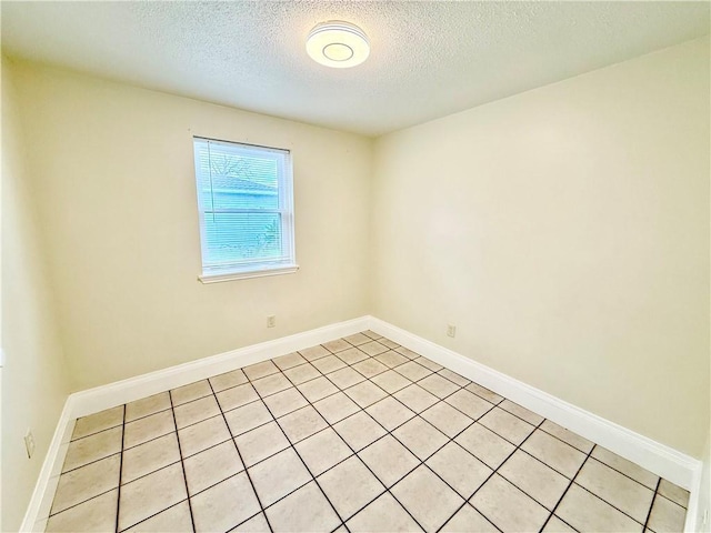 empty room with baseboards and a textured ceiling