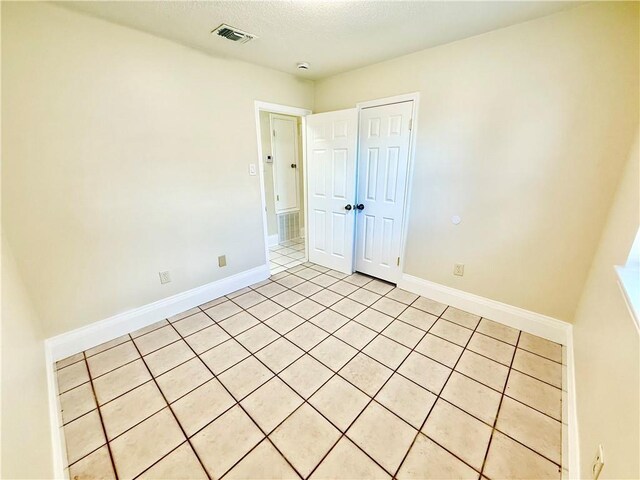 644 Willowbrook Dr, Gretna, LA 70056 - empty room with light tile patterned floors, baseboards, and a textured ceiling