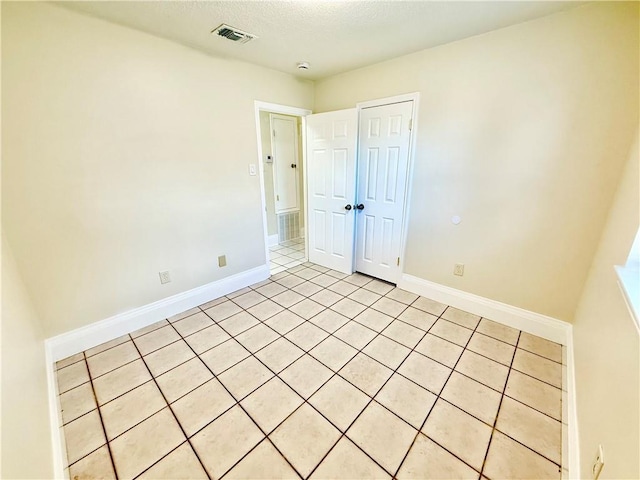 spare room with visible vents, baseboards, and a textured ceiling