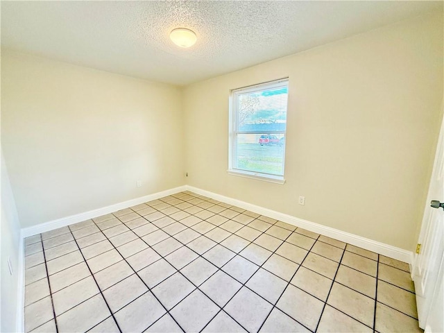 empty room featuring baseboards and a textured ceiling