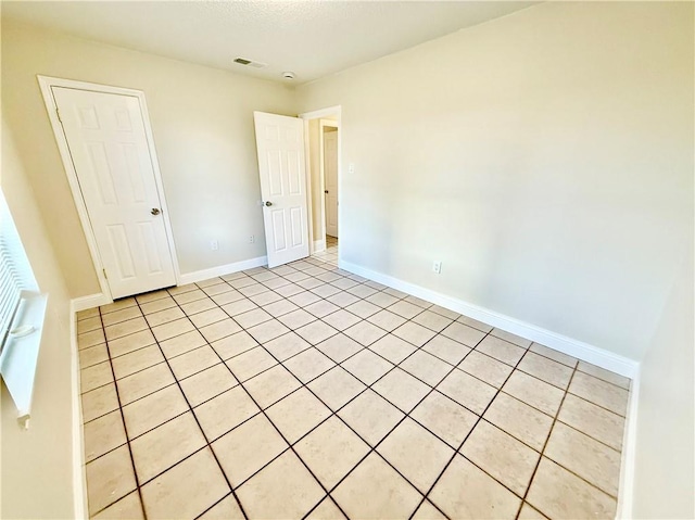 empty room featuring baseboards and visible vents