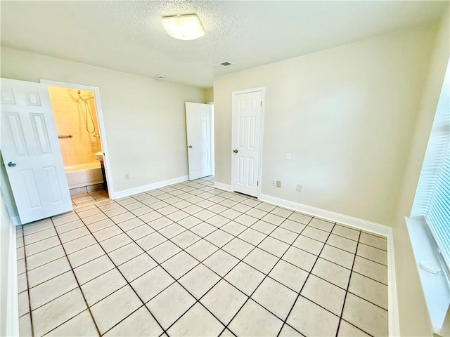 unfurnished bedroom featuring visible vents, a textured ceiling, and baseboards