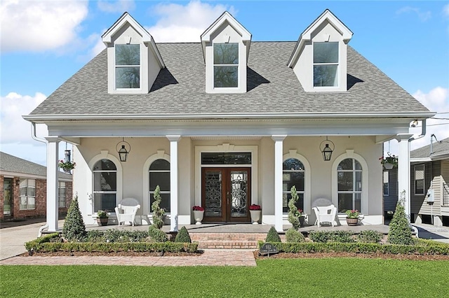 view of front of property with french doors, a porch, a front yard, and a shingled roof