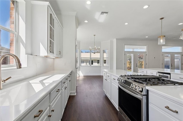 kitchen featuring visible vents, stainless steel gas stove, a sink, french doors, and an inviting chandelier