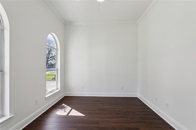 unfurnished room featuring baseboards, a healthy amount of sunlight, dark wood-style flooring, and crown molding