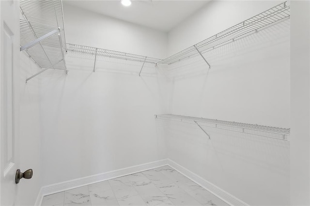 walk in closet with marble finish floor