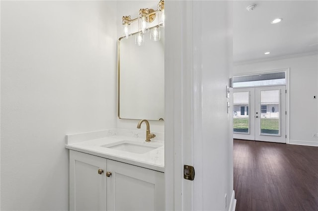 bathroom with recessed lighting, baseboards, wood finished floors, and vanity