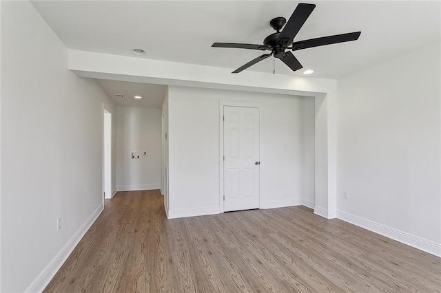 unfurnished bedroom with recessed lighting, wood finished floors, baseboards, and a closet