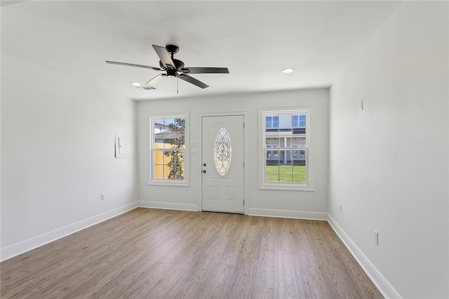 foyer entrance featuring baseboards, a healthy amount of sunlight, wood finished floors, and a ceiling fan