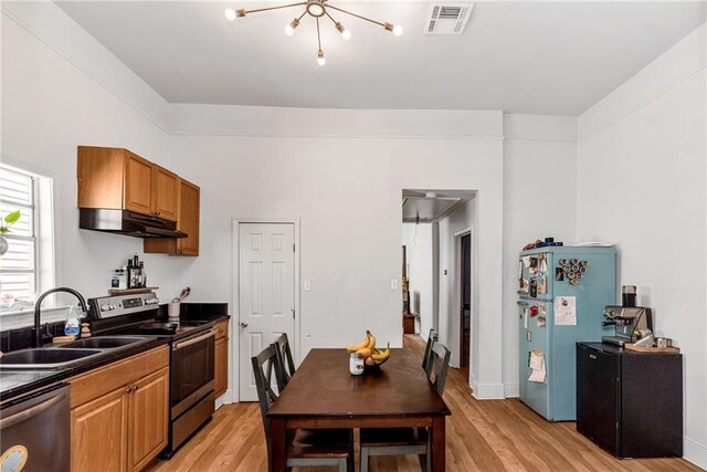 kitchen with visible vents, dark countertops, freestanding refrigerator, dishwashing machine, and stainless steel electric range oven