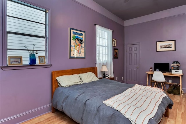 bedroom with wood finished floors and baseboards