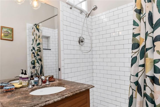 full bathroom with vanity and tiled shower