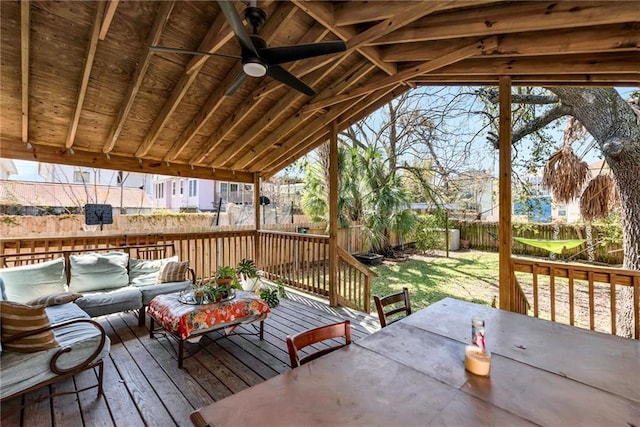 wooden terrace featuring ceiling fan, a fenced backyard, an outdoor hangout area, and outdoor dining space