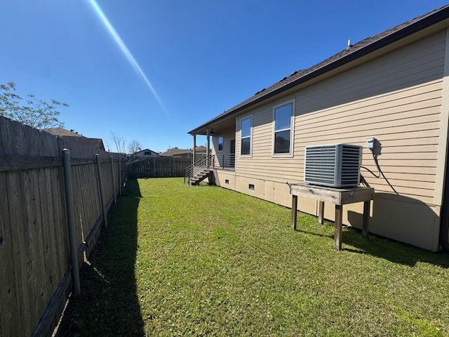 view of yard with central AC unit and a fenced backyard