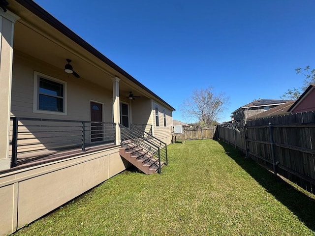 view of yard with a fenced backyard and ceiling fan