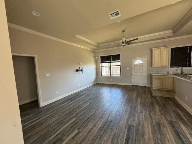 unfurnished living room featuring visible vents, baseboards, dark wood finished floors, a raised ceiling, and a ceiling fan