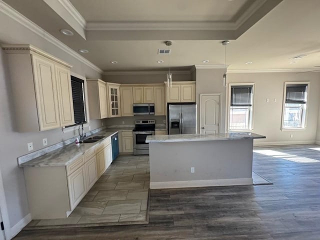 kitchen featuring visible vents, a sink, a kitchen island, stainless steel appliances, and glass insert cabinets