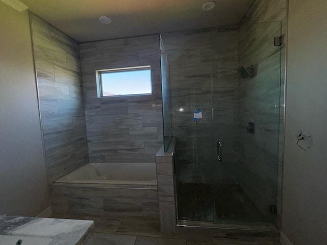 full bathroom featuring a tub with jets and a stall shower