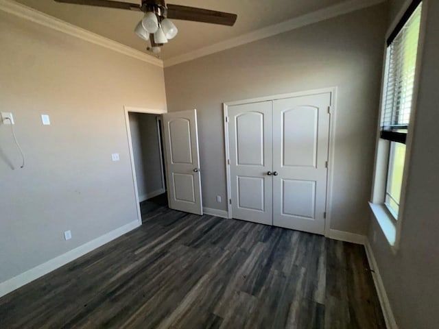 unfurnished bedroom featuring dark wood-style floors, a closet, baseboards, and ornamental molding