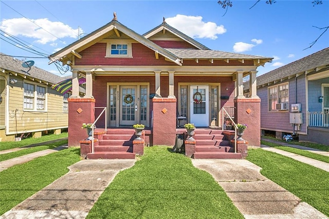 view of front of property featuring a front yard, cooling unit, covered porch, and brick siding