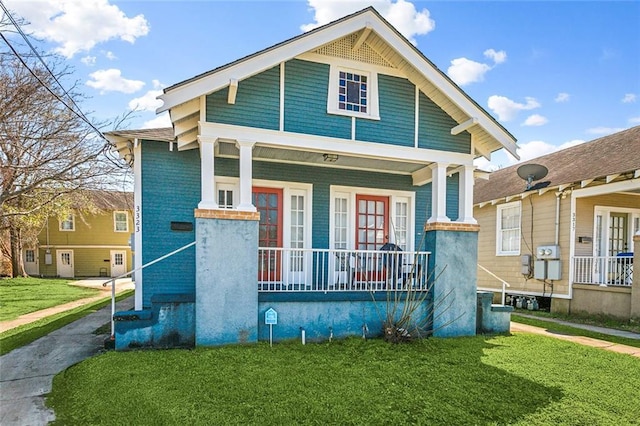 view of front of house with covered porch and a front lawn