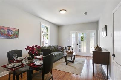 dining space featuring wood finished floors, visible vents, and baseboards