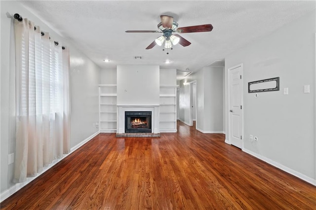 unfurnished living room featuring a brick fireplace, baseboards, a ceiling fan, and wood finished floors