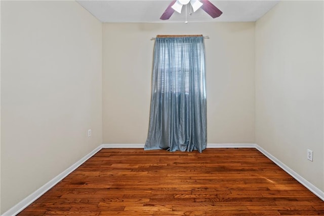 unfurnished room with baseboards, wood finished floors, and ceiling fan