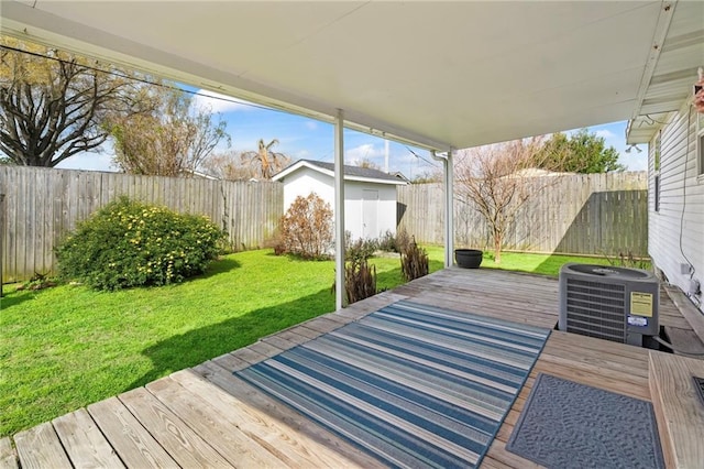 deck featuring outdoor dining area, central air condition unit, a yard, and a fenced backyard