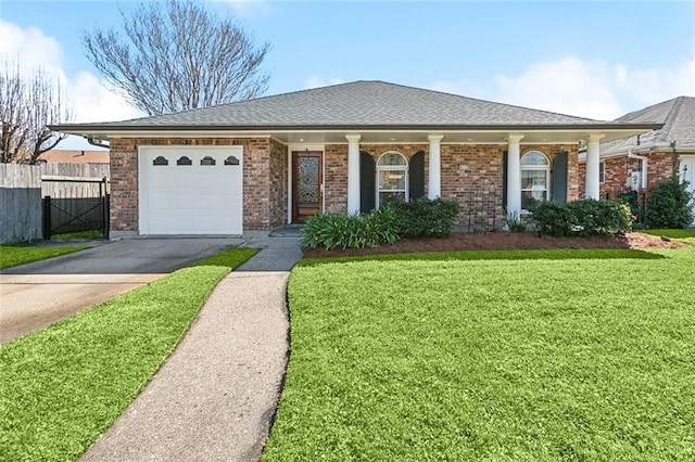 view of front of home with brick siding, concrete driveway, a front yard, and fence